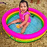 Diana is registered to the contest to win money with this photo: beach, child, family, folding_chair, girl, happy, inflatable_pool, outdoor, pink_swimsuit, portrait, sand, smiling, splashing, summer, swimming_pool, toddler, toy, vacation, water, wet_hair