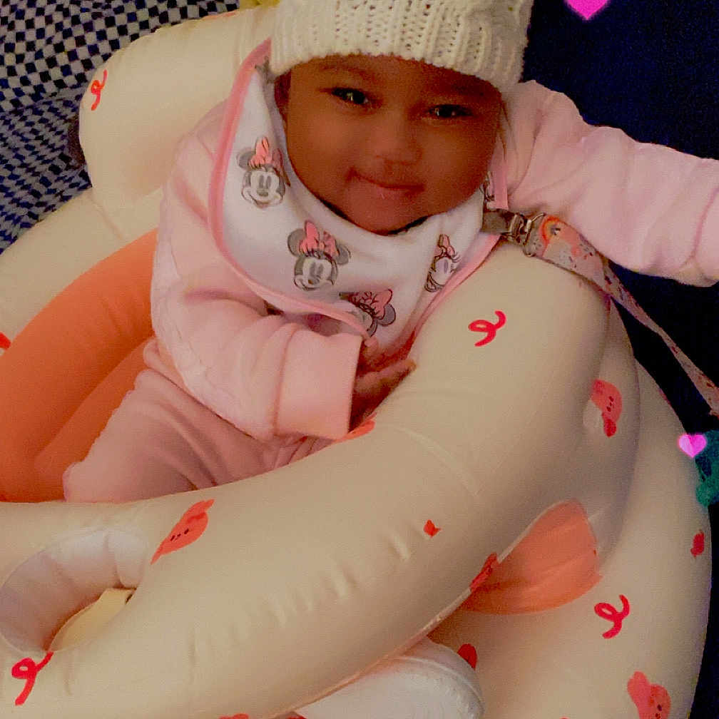 Imani joined the competition — help win amazing prizes! baby, infant, hat, knit_hat, pom_poms, bib, minnie_mouse, inflatable_seat, pink, candy_print, bear_print, heart_lights, smiling, cozy, indoors, child, cute, comfortable, person, playful