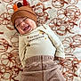 baby, infant, smiling, thanksgiving, holiday, hat, turkey_hat, blanket, pumpkin_pattern, clothing, striped_pants, cute, happy, lying_down, festive, child, portrait, indoors, celebration, cozy