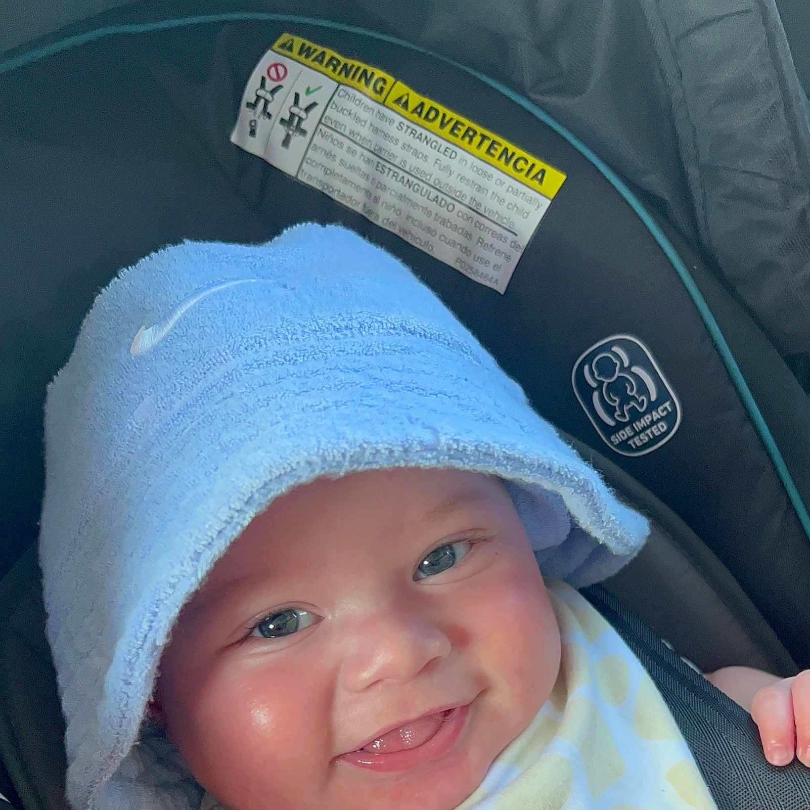 Kaisyn joined the competition — help win amazing prizes! baby, car_seat, child, closeup, clothing, cute, eyes, face, happy, hat, headwear, indoor, infant, mouth, safety_harness, seatbelt, skin, smile, tongue, towel