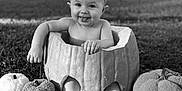 Nevaeh is registered to the contest to win money with this photo: baby, pumpkin, black_and_white, outdoor, grass, headband, tongue_out, child, cute, smile, autumn, fall, seasonal, plush_pumpkin, sign, feet, barefoot, portrait, sitting, playful
