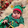 baby, child, elf_costume, christmas, holiday, festive, cute, decorations, santa, snowman, fluffy_blanket, green_hat, red_trim, indoors, portrait, holiday_spirit, costume, holiday_lights, adorable, infant