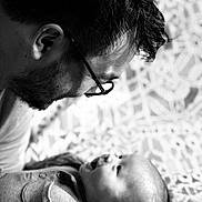 Tobyas participe au concours pour gagner de l'argent avec cette photo : baby, man, glasses, black_and_white, portrait, smile, face, love, father, child, tender, closeup, head, happy, interaction, pattern, blanket, clothing, person, family