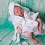 newborn, baby, sleeping, white_robe, basket, fluffy, soft, cozy, peaceful, infant, portrait, indoors, wooden_background, teal, cute, relaxed, small_feet, baby_hand, blanket, studio_photo