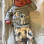 baby, infant, sleepwear, hat, blanket, face, cute, newborn, lying_down, stitch_character, clothing, patterned_pants, socks, indoor, soft_texture, portrait, child, expressive_face, comfortable, resting