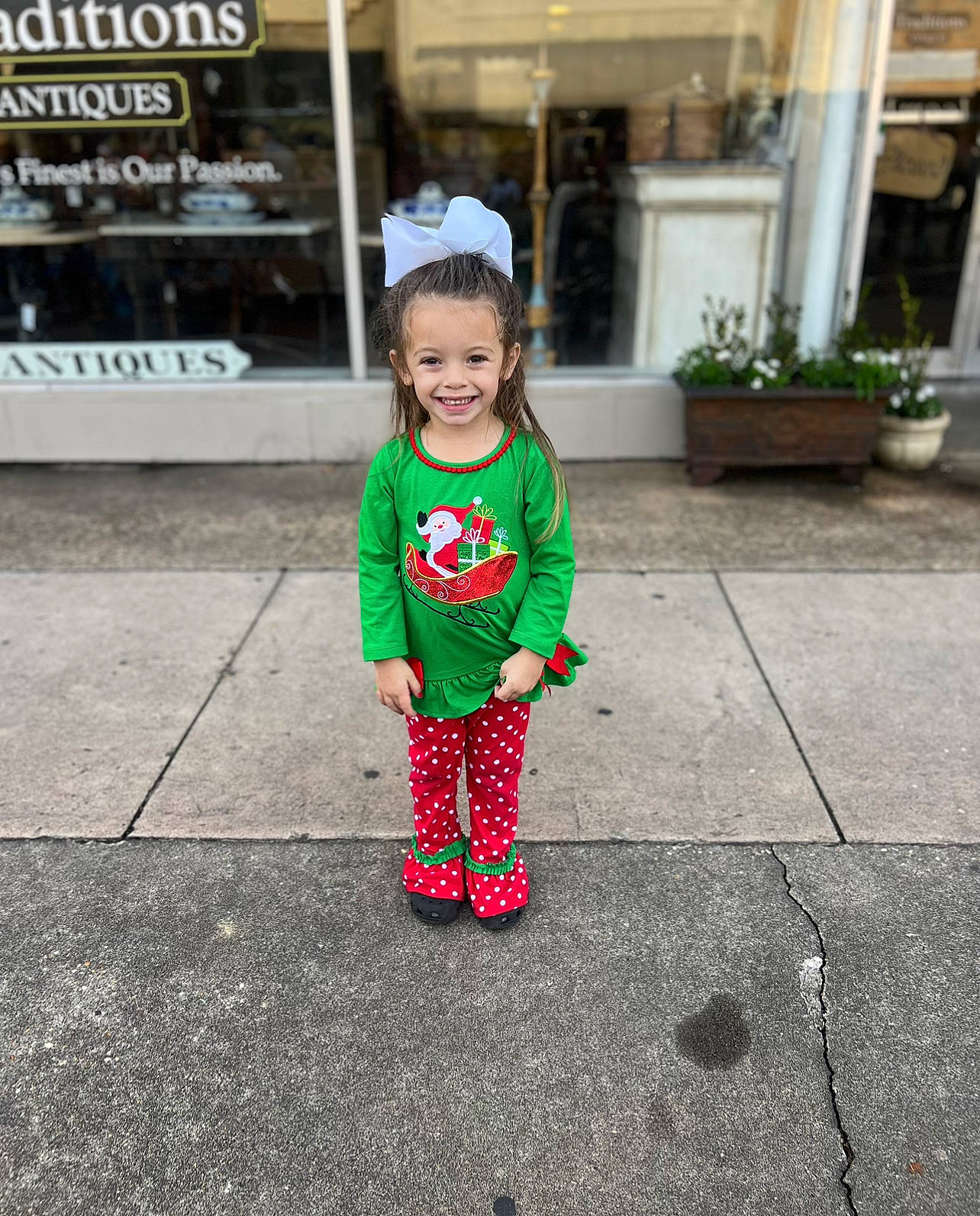 Beau is registered to the contest to win money with this photo: asphalt, baby_toddler_clothing, child, flowerpot, fun, grass, happy, hat, houseplant, joy, outerwear, pattern, person, plant, recreation, road_surface, sidewalk, sleeve, smile, toddler