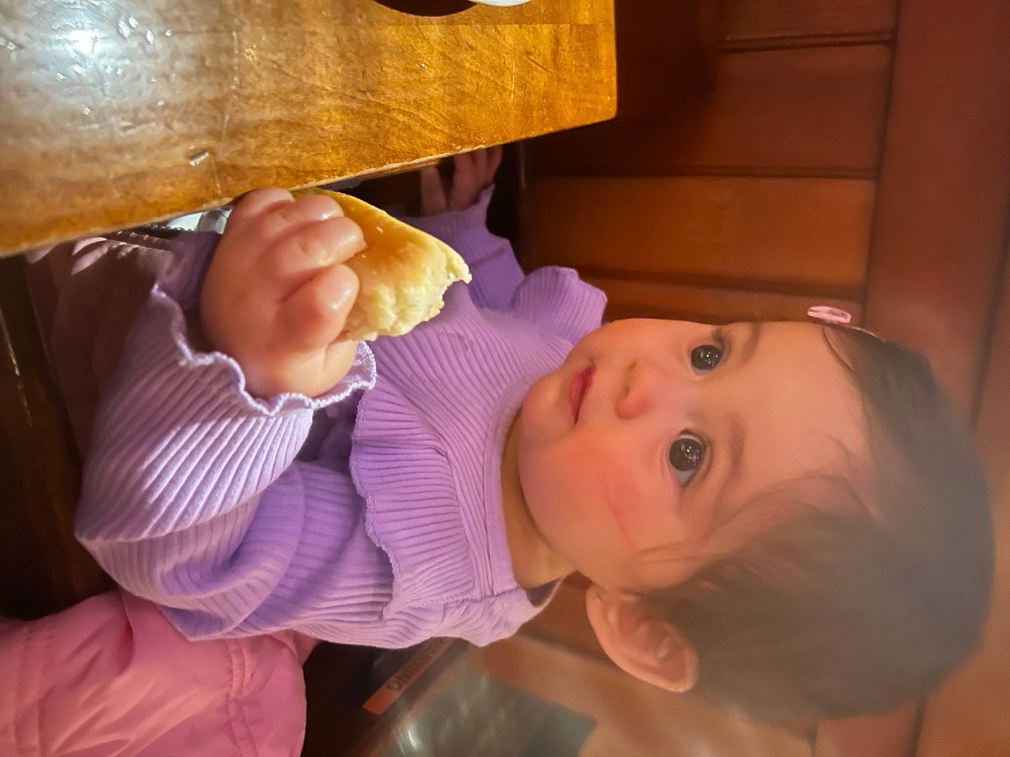 Anela is registered to the contest to win money with this photo: arm, baby, baby_toddler_clothing, finger, fun, gesture, happy, human_body, leg, mouth, nail, nose, person, skin, smile, table, tableware, thumb, toddler, wood