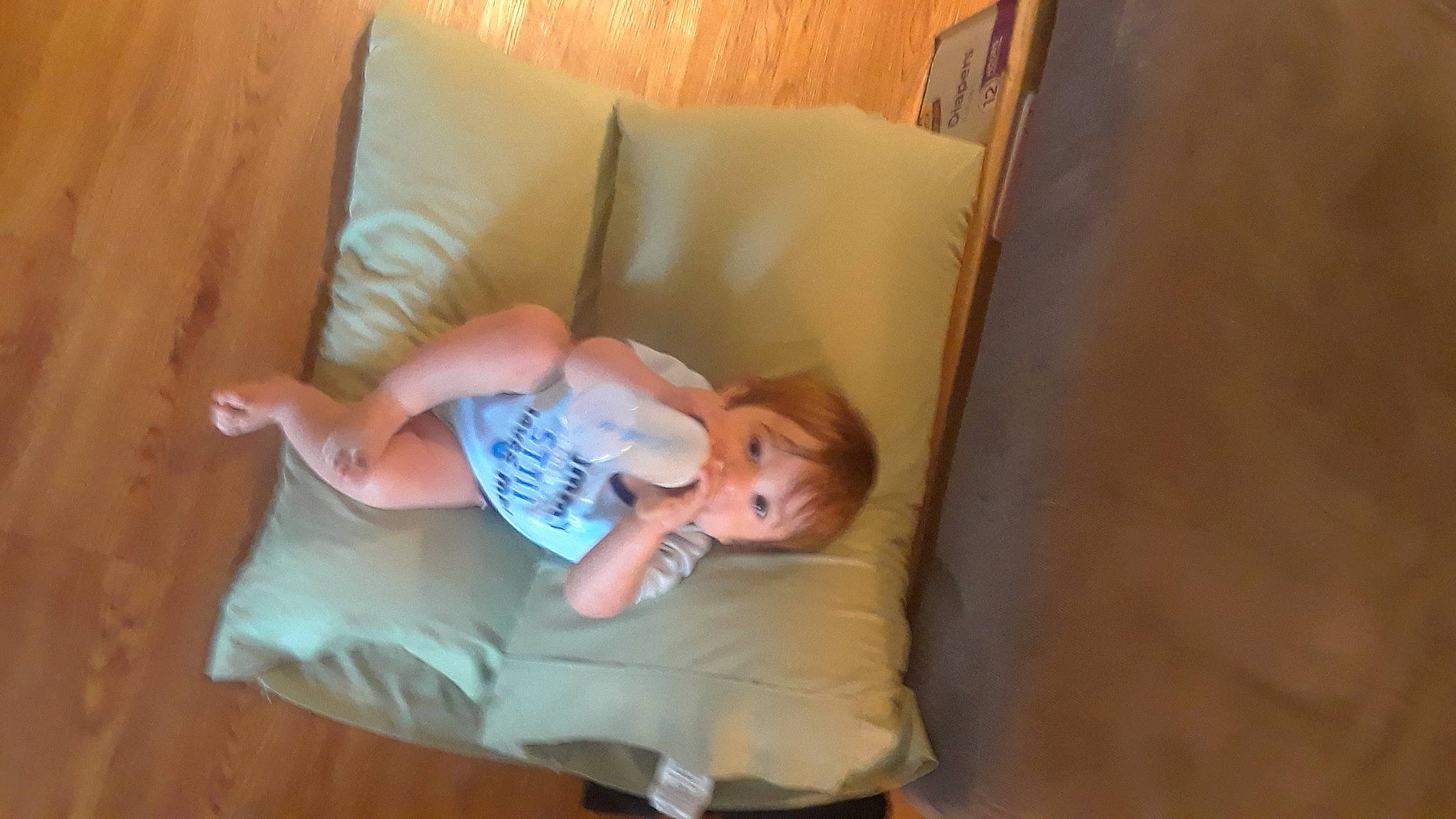 Martin is registered to the contest to win money with this photo: baby, baby_toddler_clothing, bedding, child, comfort, elbow, flooring, fun, hardwood, human_leg, knee, linens, nap, person, room, sitting, sock, thigh, throw_pillow, toddler