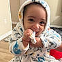 Ander is registered to the contest to win money with this photo: baby, child, infant, robe, hooded_clothing, smiling, cute, indoor, person, face, hand, soft_texture, animal_print, playful, happy, closeup, warm, comfort, cozy, expression