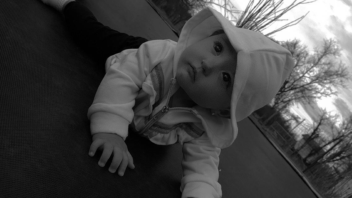 Paityn is registered to the contest to win money with this photo: baby, black_and_white, child, flash_photography, fur, gesture, grass, grey, happy, headwear, hoodie, monochrome, monochrome_photography, person, plant, portrait_photography, sitting, stock_photography, street, toddler