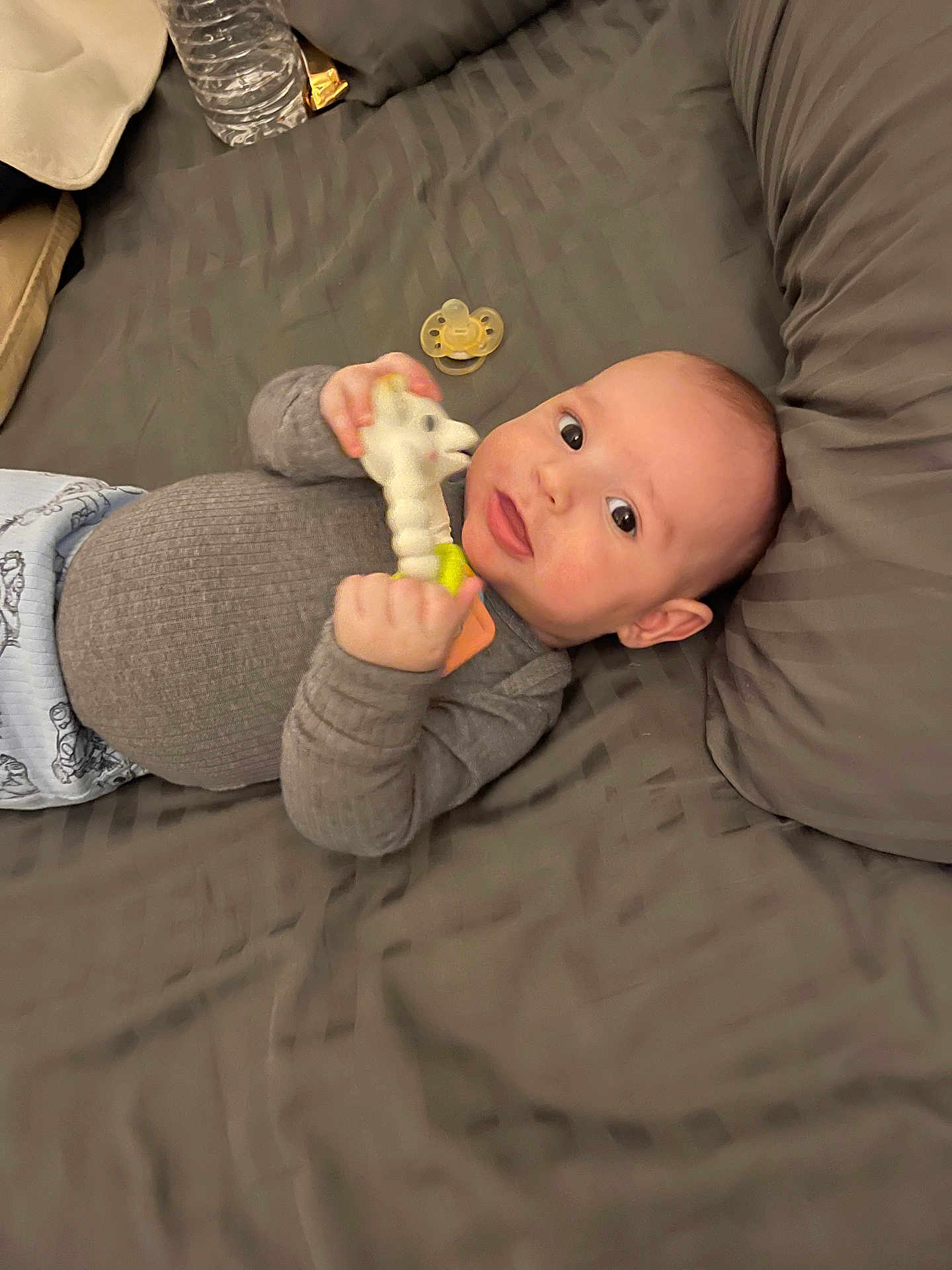 Raphaël a rejoint le concours — aidez-le/la à gagner de superbes lots ! baby, infant, toy, giraffe, bed, pillow, pacifier, sleepwear, clothing, hand, face, skin, expression, lying_down, cute, child, indoors, comfort, soft, rest