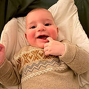 Raphaël a rejoint le concours — aidez-le/la à gagner de superbes lots ! baby, blanket, cheeks, child, cozy, cute, cute_expression, face, fingers, hand, happy, indoors, infant, infant_clothing, lying_down, patterned_sweater, portrait, smiling, sweater, warm_clothing