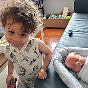 Demerious joined the competition — help win amazing prizes! toddler, baby, child, toy_car, sleeping, curly_hair, onesie, baby_lounger, couch, leather, window, wooden_floor, box, toys, indoor, person, smiling, peaceful, furniture, home