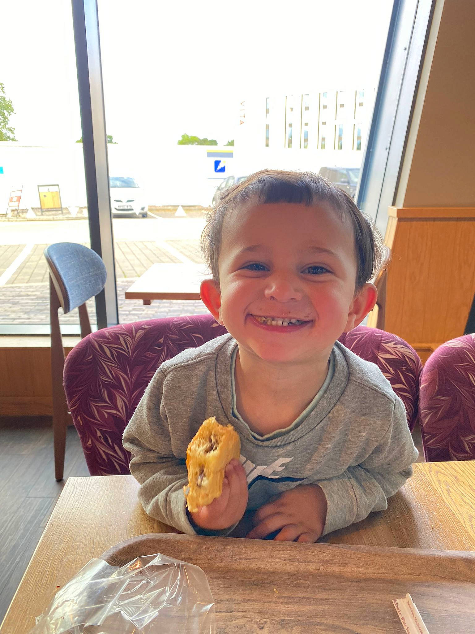 Zayan is registered to the contest to win money with this photo: baby, chair, child, comfort_food, finger, fun, furniture, happy, joy, leisure, people, person, sitting, sky, smile, table, tableware, thumb, toddler, varnish