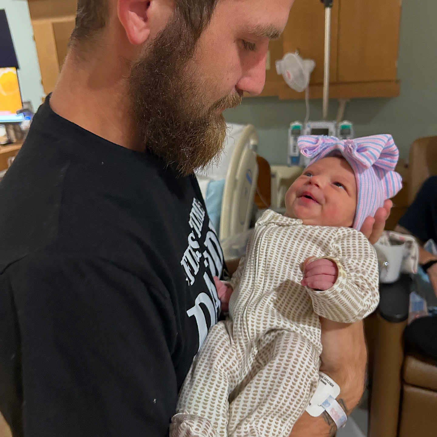 Blakelynn Elizabeth is registered to the contest to win money with this photo: baby, beard, bed, black_shirt, bow_hat, care, clothing, family, holding, hospital, indoor, infant, love, man, medical_equipment, newborn, person, portrait, smile, warmth
