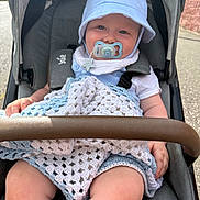 Kaijay joined the competition — help win amazing prizes! baby, stroller, pacifier, hat, blanket, crocheted_blanket, child, outdoor, sunlight, smiling, clothing, seatbelt, person, happy, headwear, infant, hand, legs, fabric, transport