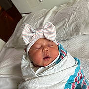 Nakiyah is registered to the contest to win money with this photo: baby, bed, blanket, bow, cute, face, hat, headwear, hospital, indoors, infant, newborn, peaceful, person, resting, sleeping, soft, swaddled, toddler, wrapped