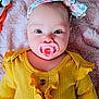 Marceline is registered to the contest to win money with this photo: baby, pacifier, headband, yellow_clothing, ruffles, blanket, plush_toy, soft_texture, infant, closeup, cute, portrait, lying_down, indoors, child, face, expression, baby_girl, colorful, comfort