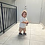 Lyzio participe au concours pour gagner de l'argent avec cette photo : accessory, casual_clothing, child, curious, door, floor, hallway, hat, indoor, keys, person, railing, sandals, serious, shirt, shorts, standing, tiles, toddler, young_child