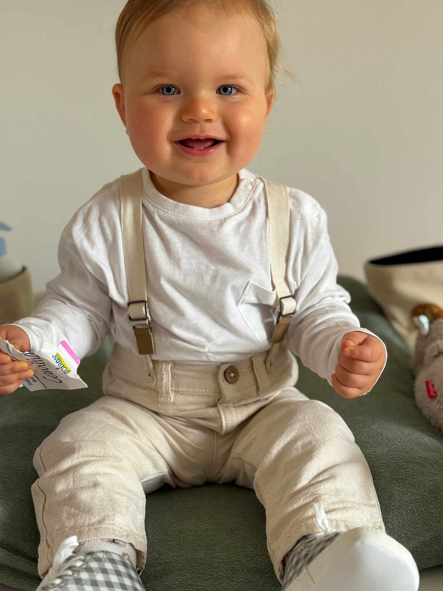 Leandro a rejoint le concours — aidez-le/la à gagner de superbes lots ! baby, child, smiling, blue_eyes, suspenders, pants, white_shirt, sitting, indoor, plush_toy, cozy, cute, happy, face, hands, footwear, home, portrait, infant, clothing