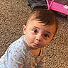 baby, child, infant, onesie, carpet, floor, shoes, pink_shelf, curious, pout, indoor, cute, person, young_child, playful, clothing, hair, face, expression, seated