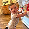 Sophie joined the competition — help win amazing prizes! baby, child, kitchen, fridge, smile, polka_dot, onesie, floor, wooden_floor, cabinet, microwave, condiments, happy, standing, person, indoor, candid, cute, exploring, hand
