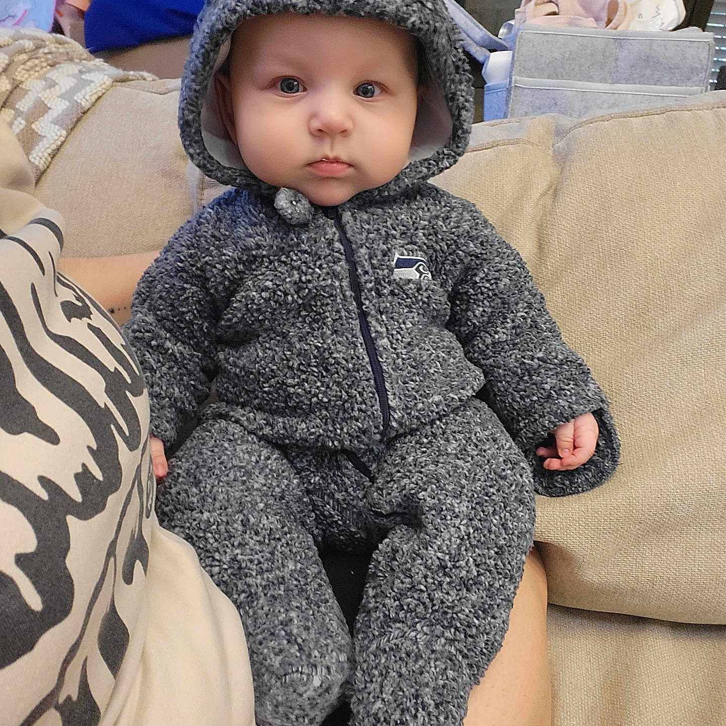 Nevaeh is registered to the contest to win money with this photo: baby, bonnet, cap, clothing, coat, couch, cushion, face, furniture, hat, head, hood, hoodie, jacket, knitwear, person, photography, portrait, sweater, sweatshirt