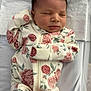 newborn, baby, sleeping, floral_onesie, blanket, infant, cute, peaceful, portrait, clothing, bed, resting, child, soft, indoors, human, small, lying_down, toddler, adorable