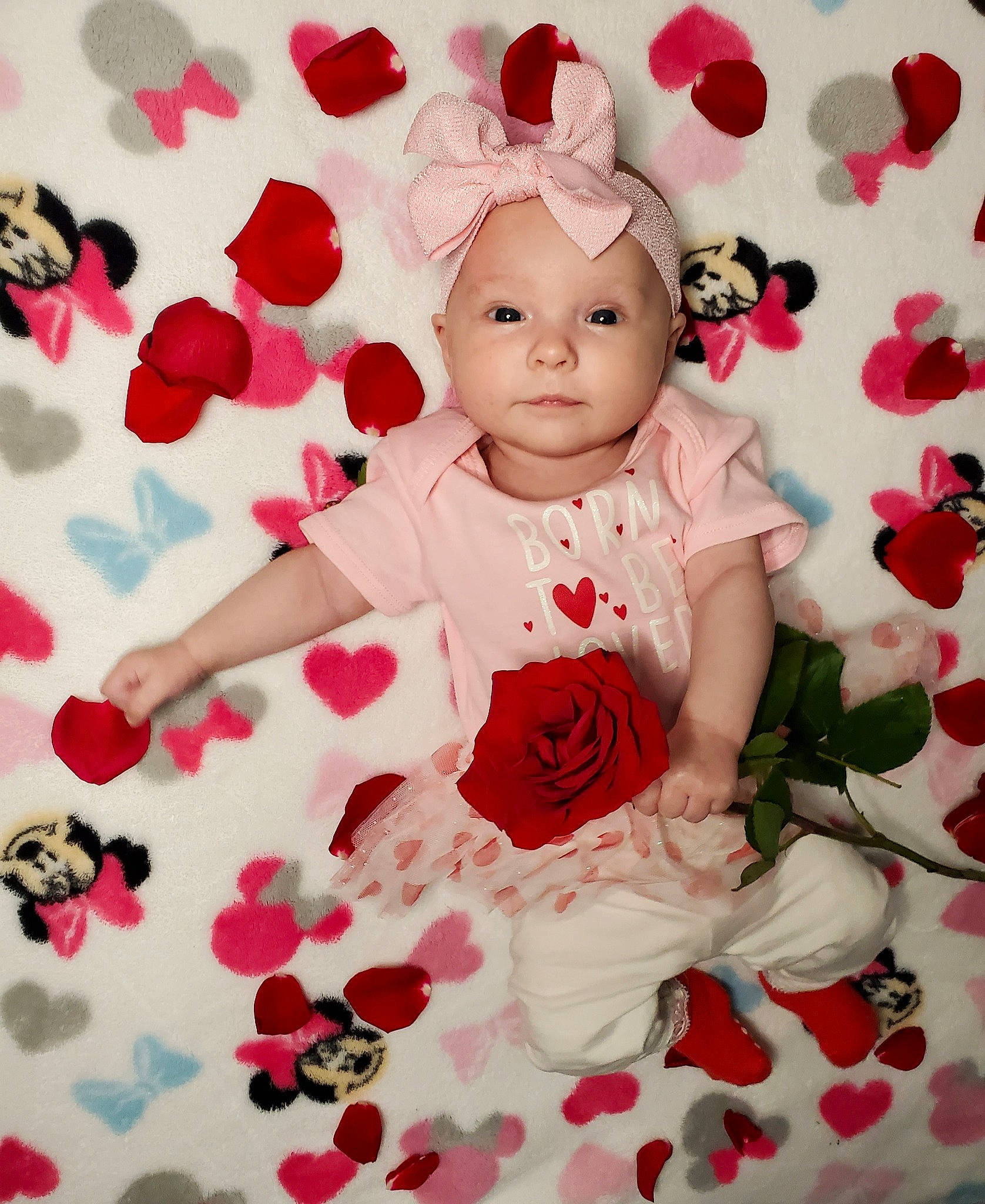 Eryn is registered to the contest to win money with this photo: baby, baby_toddler_clothing, child, cut_flowers, facial_expression, font, happy, headwear, magenta, pattern, person, petal, pink, plant, product, red, rose, sleeve, spring, textile