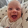Freddie is registered to the contest to win money with this photo: baby, smiling, happy, infant, face, closeup, blanket, star_pattern, cozy, indoors, cute, child, newborn, person, expression, joy, soft_light, portrait, clothing, hand