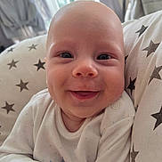 Freddie joined the competition — help win amazing prizes! baby, smile, closeup, infant, face, cute, star_pattern, cushion, white_clothing, happy, skin, head, person, child, indoors, soft_light, newborn, cheerful, portrait, cozy