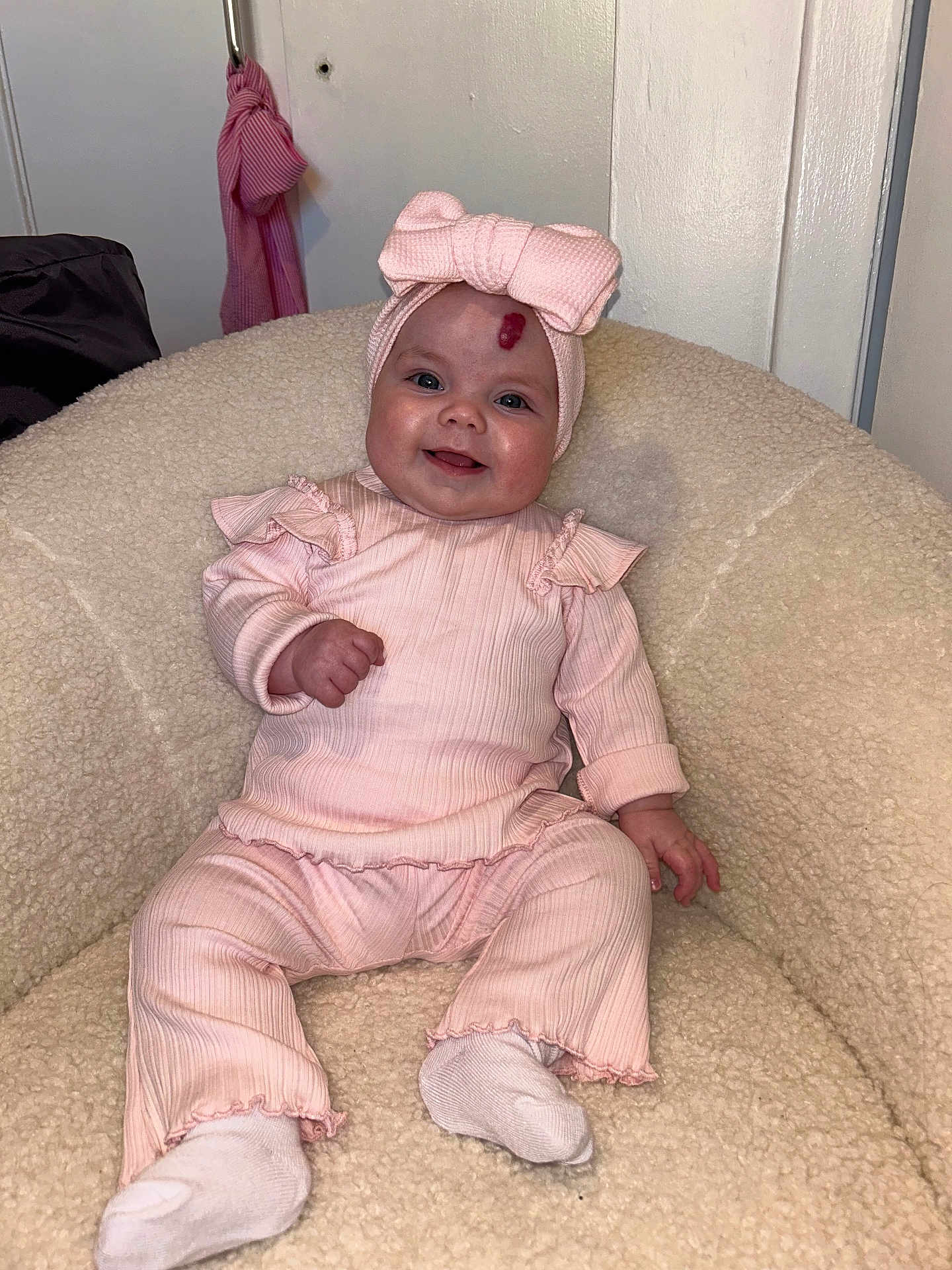 Maya is registered to the contest to win money with this photo: baby, baby_outfit, child, comfortable, cozy_chair, cute, furniture, happy, headband, headwear, indoor, infant, person, pink_clothing, portrait, sitting, smiling, sock, soft_texture, young_child