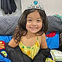accessories, bodypart, child, clothing, couch, crown, face, female, finger, furniture, girl, hand, happy, head, jewelry, person, photography, portrait, smile, tiara