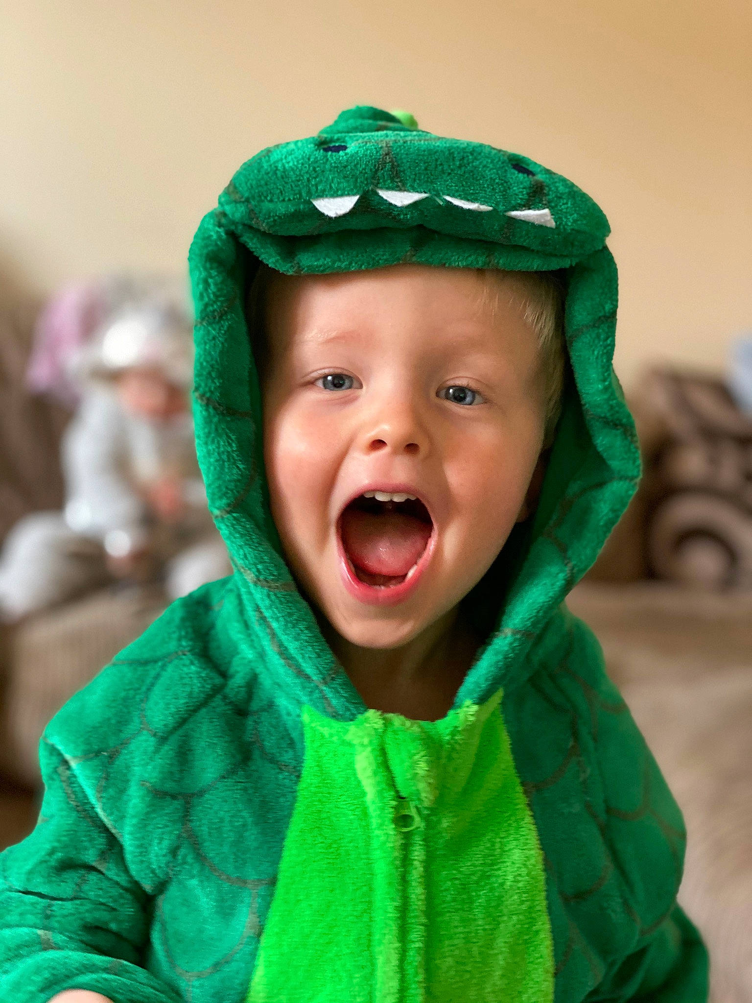 Archie is registered to the contest to win money with this photo: baby, cheek, child, face, facial_expression, fun, green, happy, head, headgear, laugh, mouth, outerwear, person, skin, smile, toddler, tongue