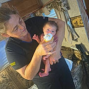 Gabriella is registered to the contest to win money with this photo: baby, woman, cupcake, indoor, holding, furniture, cushion, cabinet, curious, food, frosting, hand, person, bed, blanket, pattern, home, portrait, light, expression