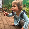 Alayah is registered to the contest to win money with this photo: blue_dress, brick_path, casual_clothing, child, colorful_shoes, crouching, curious, daylight, flowers, garden, greenery, happy, outdoor, person, pigtails, pointing, portrait, striped_leggings, toddler, young_child