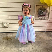 Zimmer is registered to the contest to win money with this photo: child, girl, dress, balloons, concrete_floor, pastel_colors, headband, snack, wall, vent, fan, standing, outdoor, party, celebration, pink_bow, shoes, curly_hair, colorful, young_child