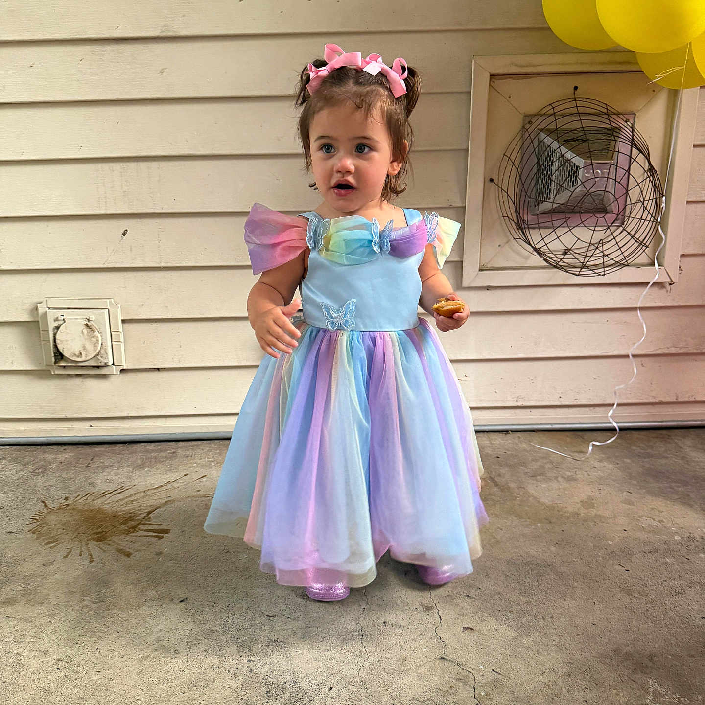 Zimmer is registered to the contest to win money with this photo: balloons, celebration, child, colorful, concrete_floor, curly_hair, dress, fan, girl, headband, outdoor, party, pastel_colors, pink_bow, shoes, snack, standing, vent, wall, young_child