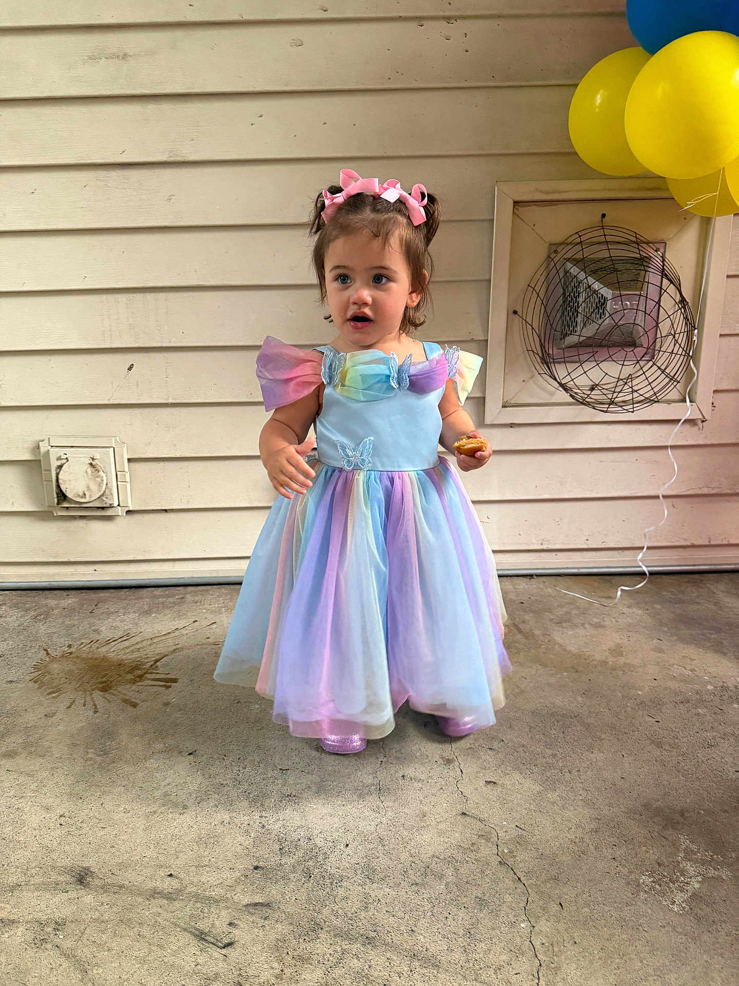 Zimmer is registered to the contest to win money with this photo: child, girl, dress, balloons, concrete_floor, pastel_colors, headband, snack, wall, vent, fan, standing, outdoor, party, celebration, pink_bow, shoes, curly_hair, colorful, young_child