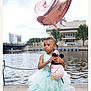 balloon, child, city, clothing, dress, face, fashion, female, formalwear, girl, gown, head, person, photography, portrait, text, water, waterfront, wedding, weddinggown