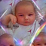 George is registered to the contest to win money with this photo: baby, infant, portrait, face, reflection, kaleidoscope, soft_light, glow, striped_blanket, hand, white_clothing, red_logo, cute, closeup, multiple_faces, blur, pastel_colors, sleepy, child, indoor