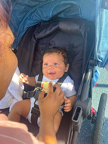 Micheal is registered to the contest to win money with this photo: auto_part, baby, baby_carriage, baby_products, car_seat, chair, child, comfort, electric_blue, event, fun, gesture, hand, person, plant, product, sitting, thumb, toddler, wheel