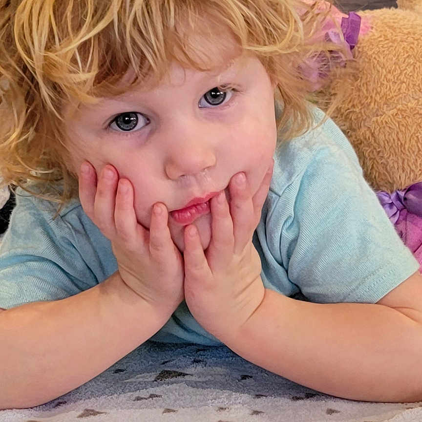 Mackenzie is registered to the contest to win money with this photo: baby, bed, blanket, blonde, bodypart, clothing, cushion, face, finger, furniture, hair, hand, head, homedecor, indoors, person, photography, portrait, quilt, t_shirt