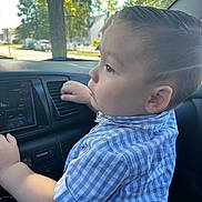 Isaac joined the competition — help win amazing prizes! child, toddler, car, dashboard, shirt, blue_checkered, hand, face, side_view, sunlight, window, tree, seat, interior, curious, young, person, daylight, casual, exploring