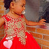 Ashanti Singleton joined the competition — help win amazing prizes! toddler, child, dress, red_dress, pacifier, window, brick_wall, curly_hair, embroidery, portrait, side_view, indoors, cute, baby, person, hand, face, hair_tie, looking_away, young_child