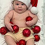 baby, santa_hat, christmas_ornaments, red_balls, blanket, holiday, festive, cute, infant, smiling, blue_eyes, chubby, skin, shorts, holiday_decor, celebration, indoors, portrait, child, holiday_hat