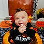 baby, pumpkin, halloween, costume, infant, holiday, orange, black_clothing, festive, smiling, hands, decoration, autumn, cute, celebration, indoors, child, seasonal, happy, portrait