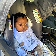Liam is registered to the contest to win money with this photo: accessory, baby, baby_clothes, bib, car_interior, car_seat, child, clothing, cute, expression, indoors, infant, newborn, pacifier, person, portrait, safety, seat, seatbelt, young_child