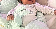 Liam is registered to the contest to win money with this photo: baby, bed, blanket, child, comfort, cozy, cute, dinosaur, hand, happy, head, indoors, infant, lying_down, person, pillow, plush, sleepwear, smile, soft