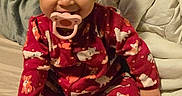 Nala Ann is registered to the contest to win money with this photo: toddler, child, pacifier, pajamas, curly_hair, bed, blanket, pillow, indoor, smiling, cute, baby, sitting, red_clothing, animal_print, cozy, young_child, person, infant, happy